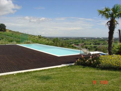 piscina rettangolare con bordo sfioro un lato panoramico